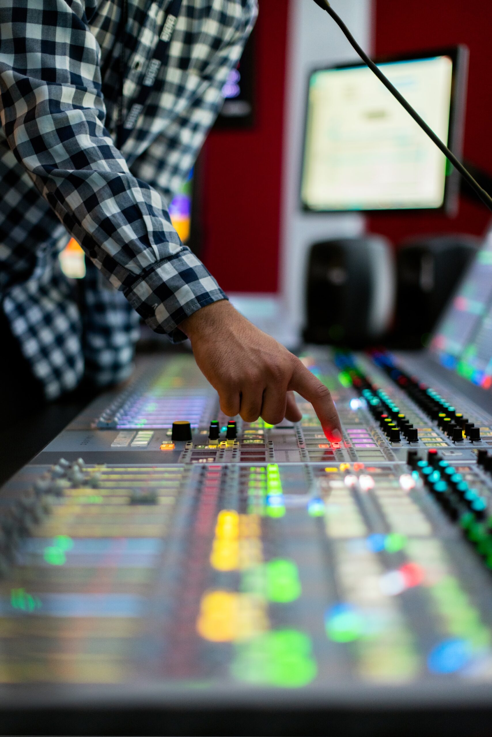 a person using a sound mixing console in music studio